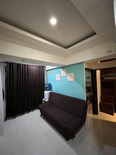 バンドンにあるTHE JARRDIN CIHAMPELAS by RA APARTMENT NEWの青い壁のリビングルーム(ソファ付)