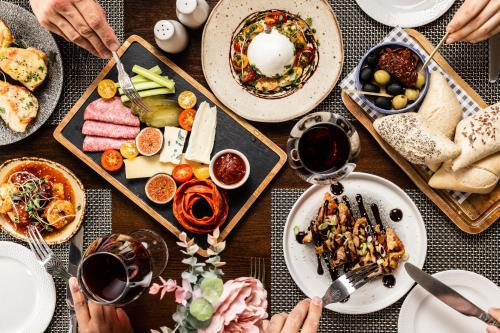 a table topped with plates of food and glasses of wine at The Monterey Hotel - Sure Hotel Collection by Best Western in Saint Helier Jersey