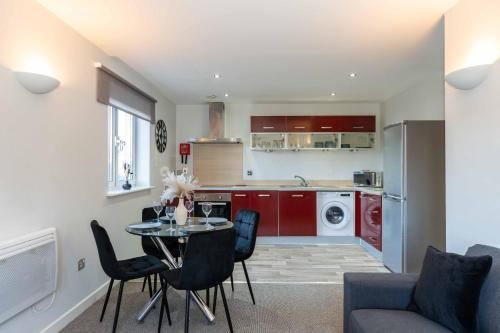 a kitchen and living room with a table and chairs at Cotels Centro Budget Busting Apartments! CENTRAL LOCATION, PARKING, FIBRE WIFI, SMART TV, FULLY EQUIPPED KITCHEN in Northampton