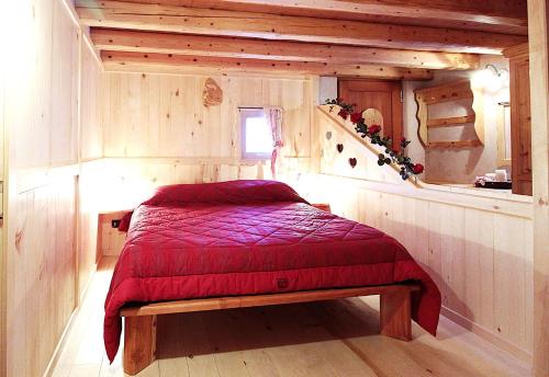 a bedroom with a bed with a red blanket at Baita Mountain View Pale San Martino in Fiera di Primiero