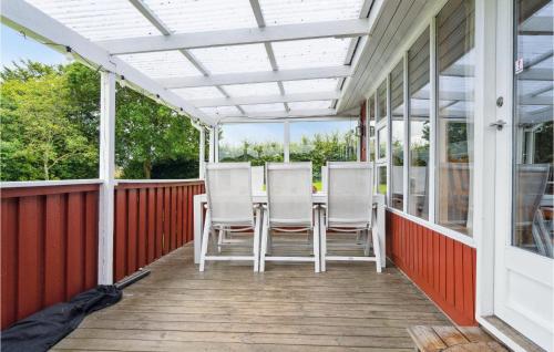 a porch with white chairs and a white pergola at Holiday Home Haslevgårde Bakker Hadsund Xii in Haslevgårde