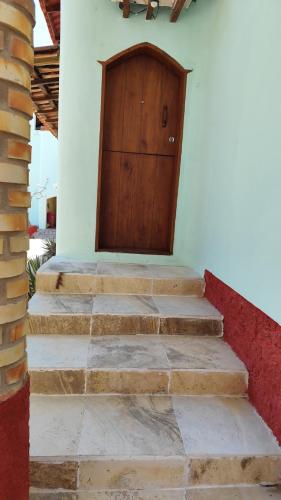 a set of stairs with a wooden door on a house at Espaço Akronos Residence in Canoa Quebrada