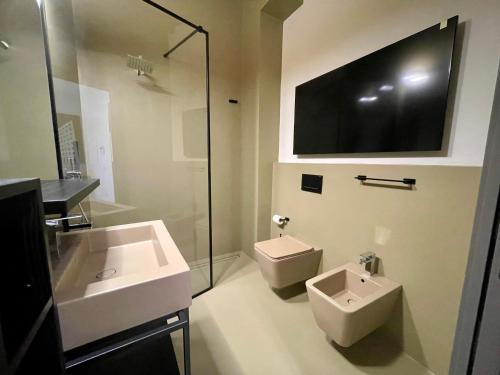 a bathroom with a sink and a toilet and a tv at Appartamenti Saragozza a due passi da Piazza Grande - WIFI e parcheggio gratuito in Modena