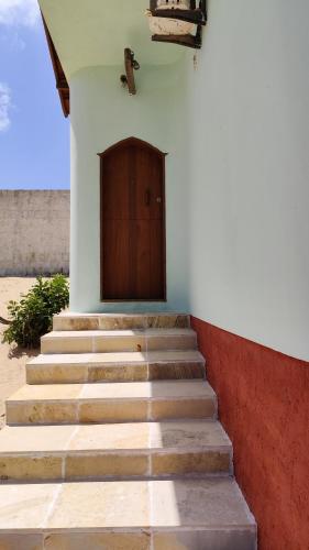 a set of stairs leading up to a building with a door at Espaço Akronos Residence in Canoa Quebrada