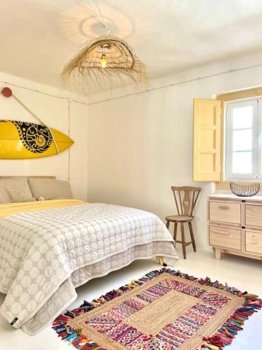 a bedroom with a bed and a rug on the floor at Boutique Surf House in Surf Paradise in Santo Isidoro