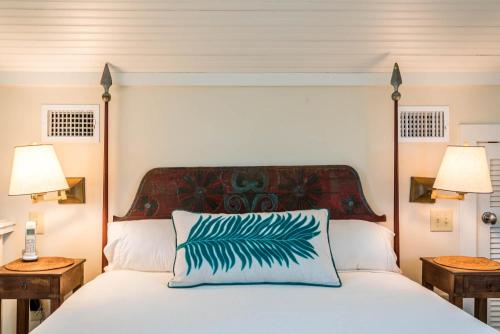 a bedroom with a white bed and two lamps at Belize Carriage House in Rosemary Beach