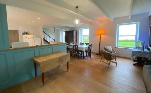 un salon avec une cuisine et une salle à manger dans l'établissement House on the golf course with sea views, à Carantec