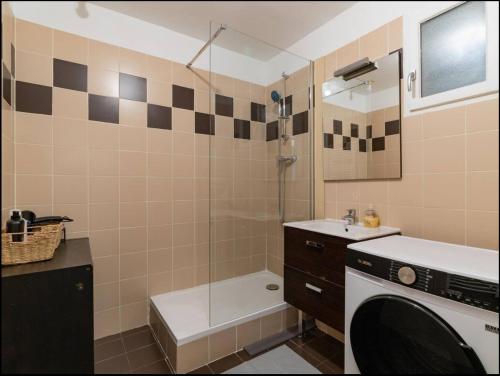 une salle de bain avec douche et lavabo et une machine à laver dans l'établissement Appart sur la rue de la république, à Marseille