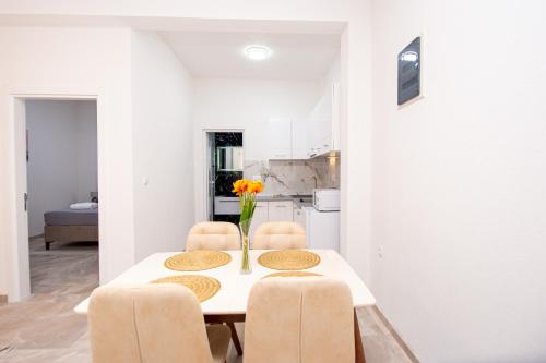 a dining room table with chairs and a vase of flowers on it at Stone Villa with pool Montenegro Star in Kaluđerac