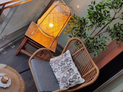 a wicker chair with a pillow on a balcony at Pilies VIP apartaments in Vilnius