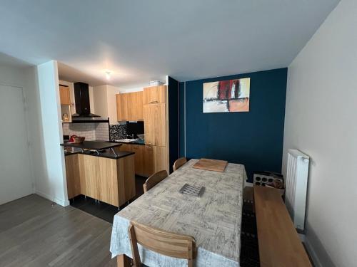 une salle à manger avec une table et une cuisine dans l'établissement Appartement aux portes de Paris, à Saint-Ouen