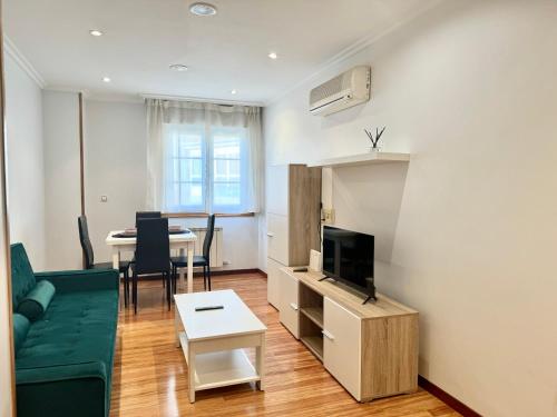 a living room with a green couch and a table at La Perla del Castro in Vilagarcia de Arousa