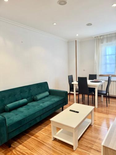 a living room with a green couch and a table at La Perla del Castro in Vilagarcia de Arousa