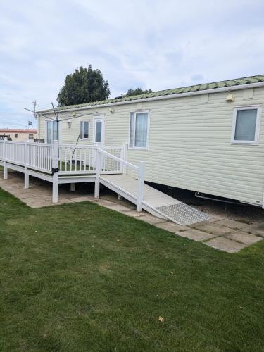 a mobile home with a porch and a deck at Disabled access C10 Millfields caravan park 2 bedrooms lead person must be over 30 in Ingoldmells