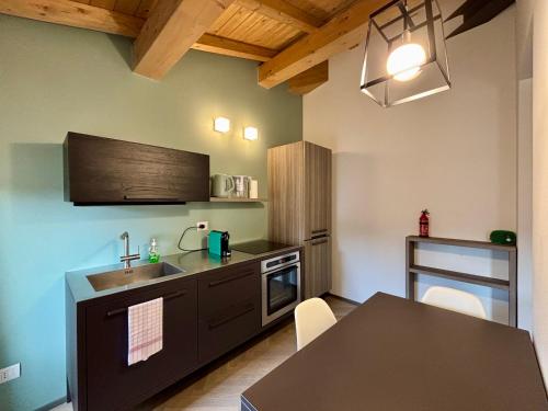a kitchen with a sink and a table at Appartamenti Saragozza a due passi da Piazza Grande - WIFI e parcheggio gratuito in Modena