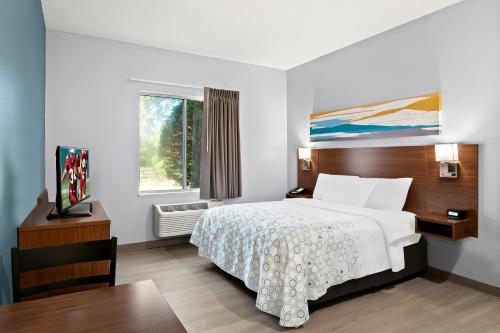 a hotel room with a bed and a window at HomeTowne Studios by Red Roof East Lansing - Okemos in Okemos