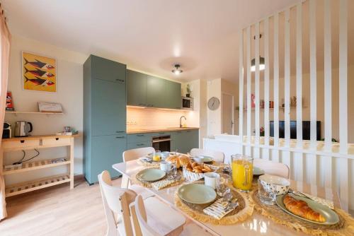 une salle à manger avec une table sur laquelle se trouve de la nourriture dans l'établissement Sophos by Kleidos, Disney 15 min, 1 Lit King Size, appartement pour 6P avec parking, à Bussy-Saint-Georges