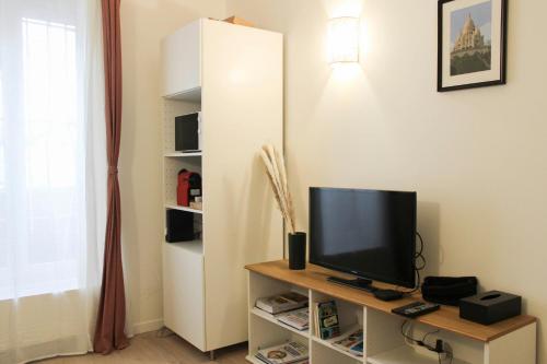 un salon avec une télévision sur une table dans l'établissement Charming studio for two at the gates of Paris, à Aubervilliers