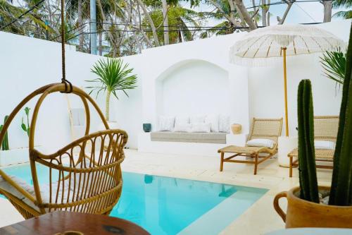 a room with a pool and chairs and a cactus at Inlander Villas A- Private pool luxury Villa in Gili Trawangan