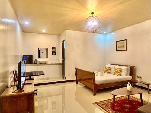 a living room with a couch and a tv at E&R Airport Hotel in Dumaguete
