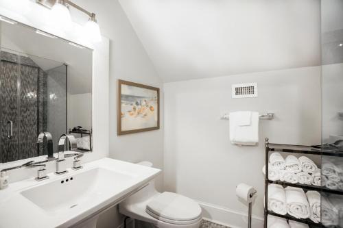 a white bathroom with a sink and a toilet at Benoit Cottage in Rosemary Beach