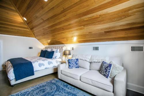a bedroom with a bed and a white couch at Benoit Cottage in Rosemary Beach
