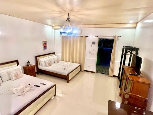 a room with two beds and a television in it at E&R Airport Hotel in Dumaguete