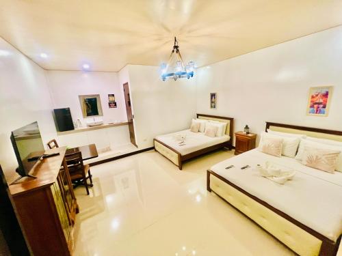 a living room with two beds and a desk at E&R Airport Hotel in Dumaguete