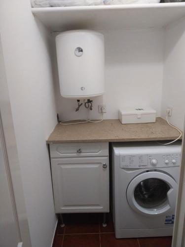 a small kitchen with a washing machine and a sink at Casa Santa Maria apartamento B in Ermidas