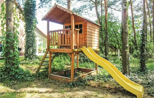 a small wooden play house with a slide at Nice Home In Solec Wlkp, With Wifi in Sulęcinek