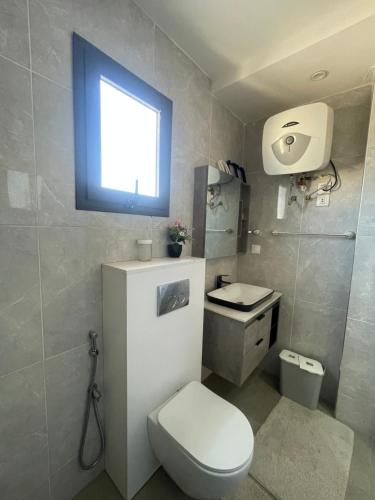 a bathroom with a toilet and a sink and a window at BBImmo APPART HOTEL in Dakar