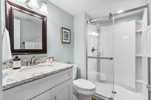 a bathroom with a toilet and a sink and a shower at Windemere Beachfront Oasis with Hot Tub and Pool Access in Myrtle Beach
