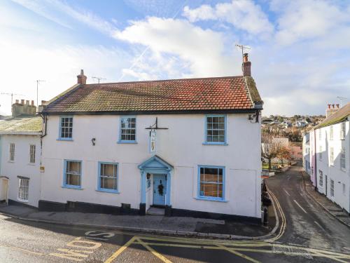 a white building with a cross on the front at Old Monmouth in Lyme Regis