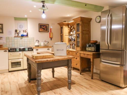a kitchen with a wooden table and a refrigerator at Old Monmouth in Lyme Regis