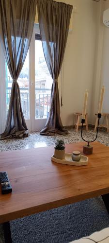 a living room with a wooden table and curtains at Eternal Acropolis Suites in Athens