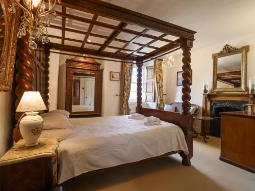 a bedroom with a large wooden canopy bed and a fireplace at Old Monmouth in Lyme Regis