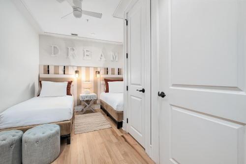a small bedroom with two beds and a doorway at Rose at Mercado in Rosemary Beach