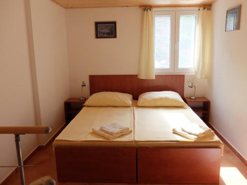 a bedroom with a bed with two towels on it at Apartments Sunce in Brna