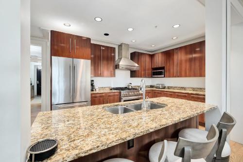 a kitchen with a granite counter top and wooden cabinets at Rose at Mercado in Rosemary Beach