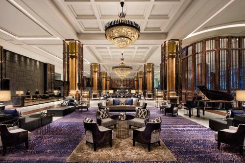 a lobby with couches and a grand piano at Bangkok Marriott Marquis Queens Park in Bangkok