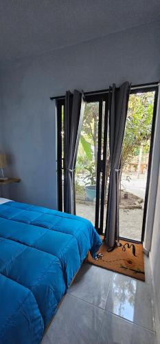 a bedroom with a blue bed and a window at Casa Amarilla Tecámac in Santa Cruz Tecamac