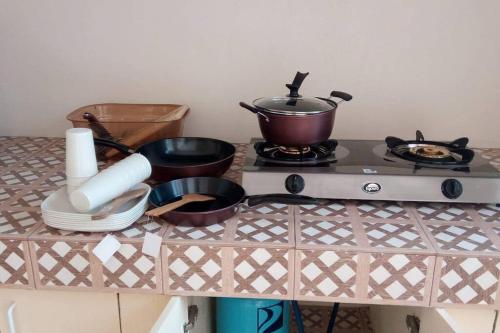 a stove with pots and pans on top of it at JMC1 Room1 Tagbilaran City Bohol in Tagbilaran City