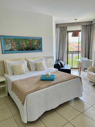 a bedroom with a large bed and a balcony at Condomínio Aldeia dos Reis in Mangaratiba