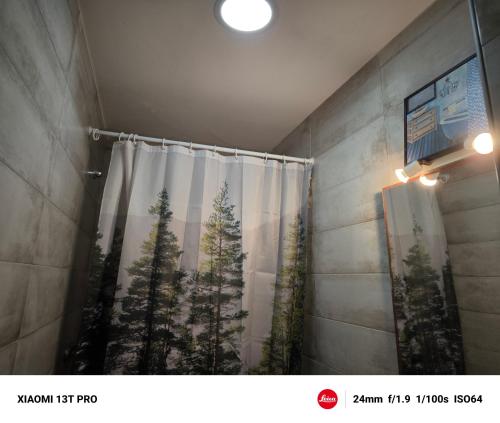 a bathroom with a shower curtain with pine trees at El Mirador"Venerable Escuder" in Cocentaina