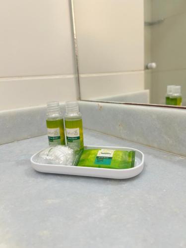a tray with two bottles of mouthwash and a container at Condomínio Aldeia dos Reis in Mangaratiba
