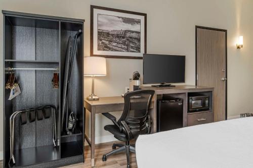 a hotel room with a desk with a monitor and a computer at Best Western Plus The Inn at Hells Canyon in Clarkston