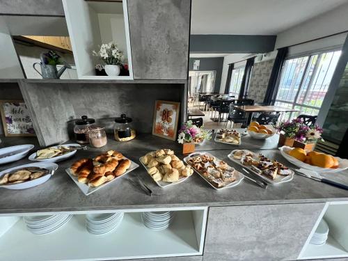 a buffet with many different types of bread and pastries at Hotel Posada del Ángel in Villa Carlos Paz