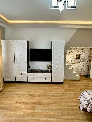 un soggiorno con una grande televisione e mobili bianchi di HomeSweetHome a Chişinău
