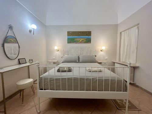 a bedroom with a white bed and a mirror at Casa Bent in Pescara