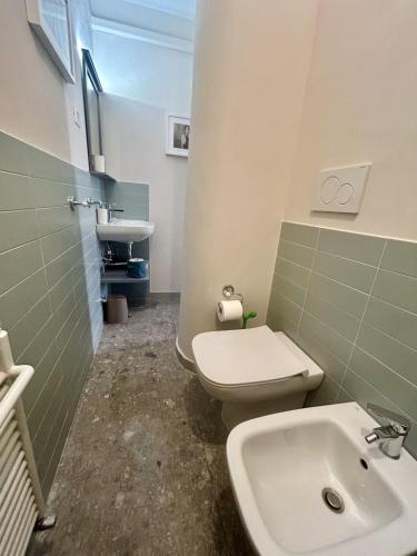 a bathroom with a white toilet and a sink at Casa Bent in Pescara